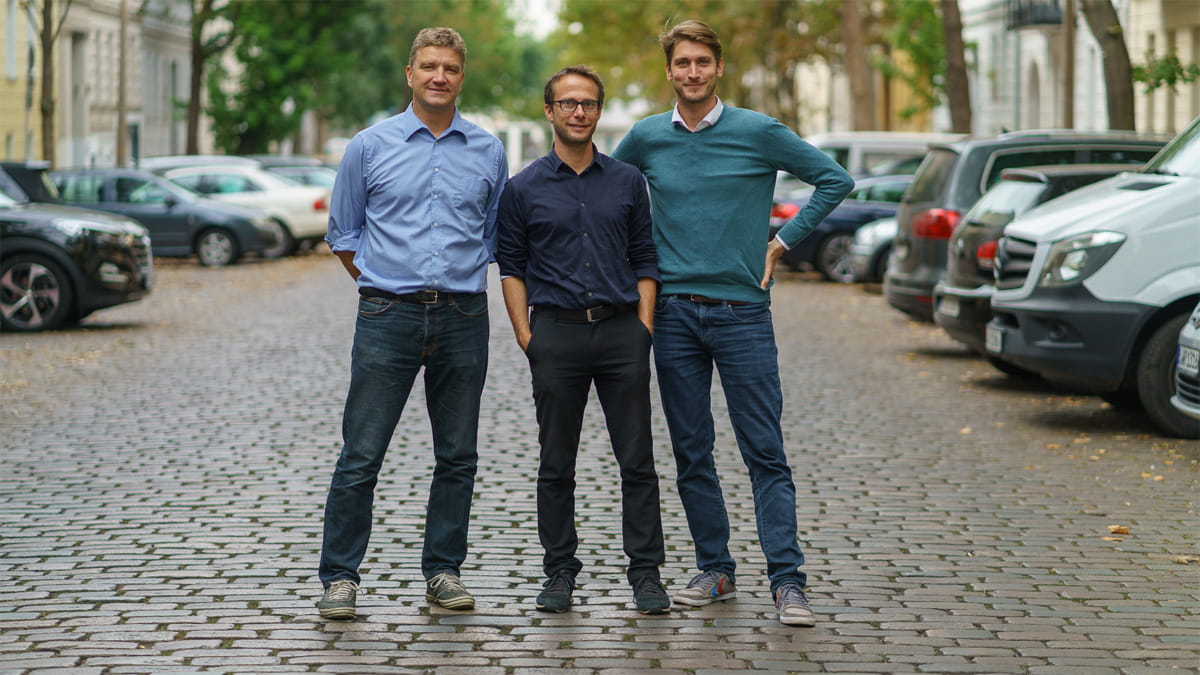 Halbnahe Aufnahme der drei Gründer von NÜWIEL, das smarte Lastenanhänger für Fahrräder anbietet, welche umweltschonende eine Last Mile Delivery gewährleisten.