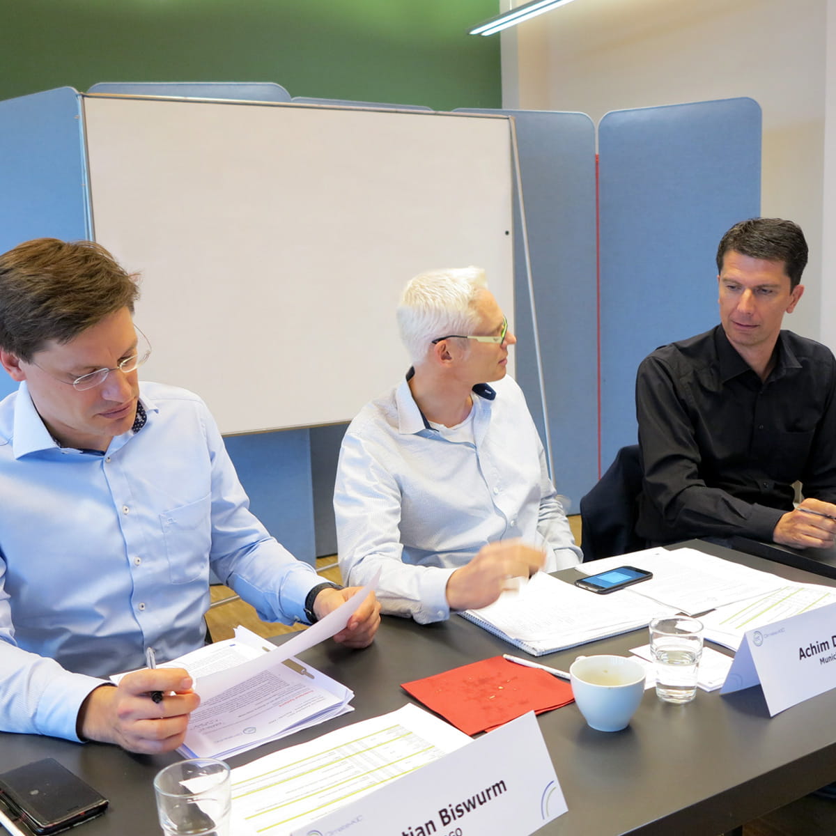 Drei Jury-Mitglieder sitzen an Tischen beim Pitchday des Climate-KIC-Acceleratorprogramms im September 2017 in Berlin.