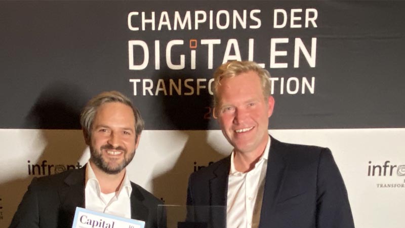 Gregor Wiest und Mark Klein von ERGO freuen sich über die Auszeichnung "Champions der Digitalen Transformation".